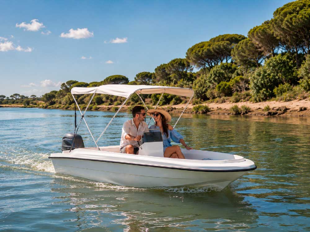Barco de alquiler en la costa de Huelva, El Rompido, Isla Canela: pareja paseando en una lancha con toldo