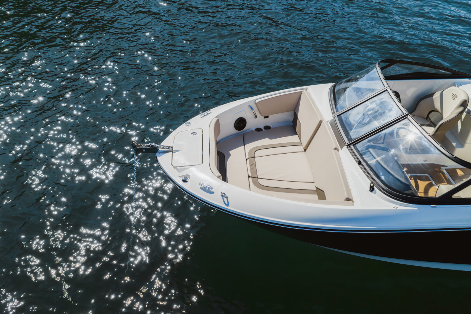 Barco Bayliner: blanco con bañera y cabina abierta navegando sobre el agua, ideal para alquiler de embarcaciones en Andalucía