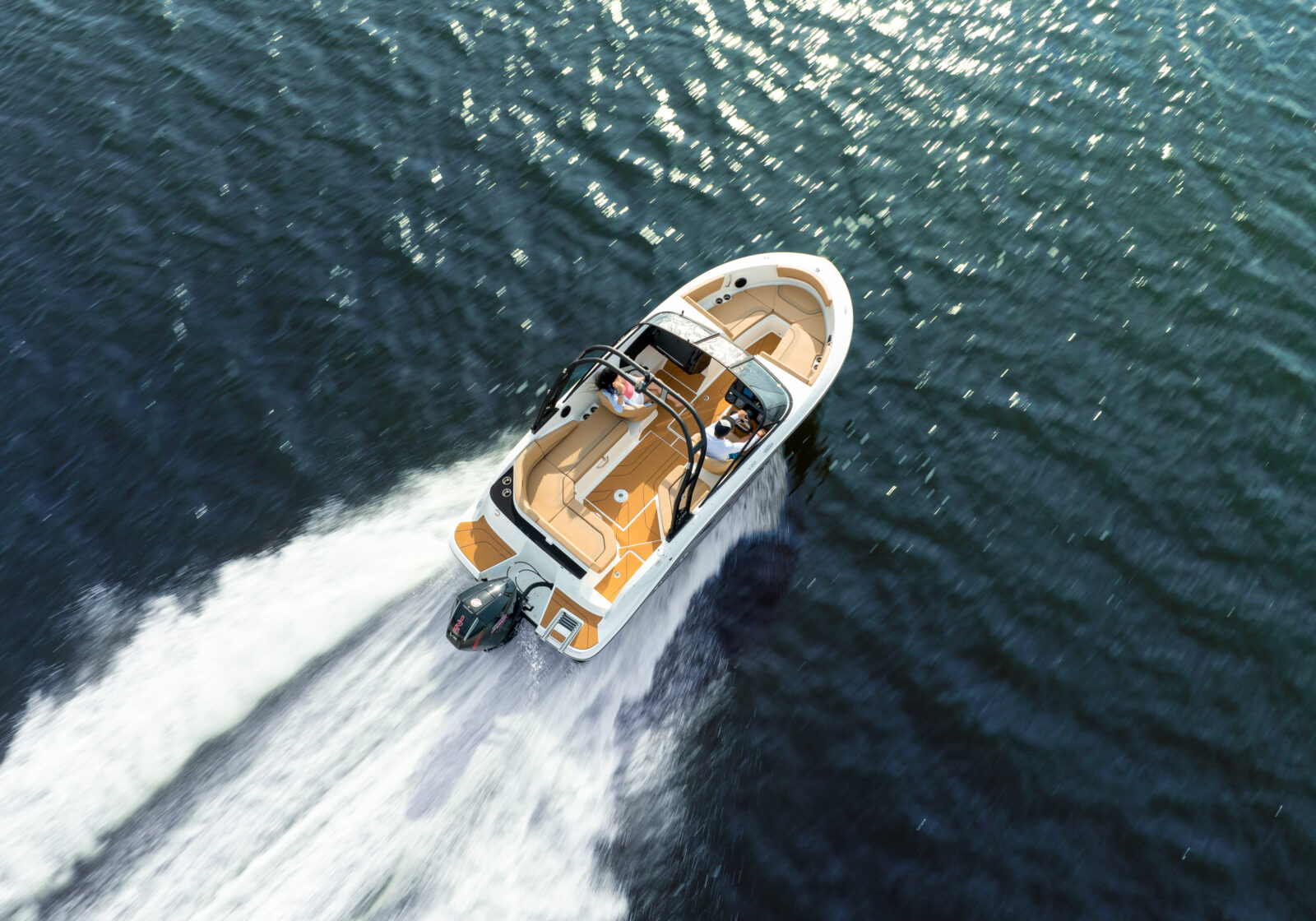 Barco motor Nuva Yacht navegando sobre el agua con pasajeros, con estela en el mar.