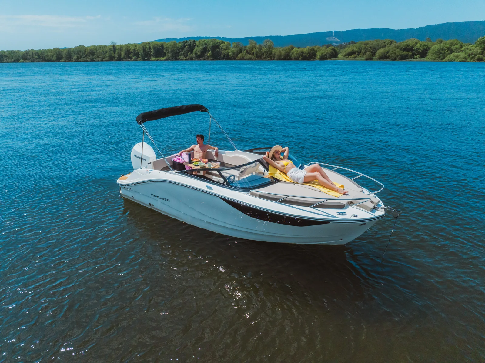 Barco a motor Bayliner con personas en el agua, ideal para alquiler náutico en Huelva y El Rompido.